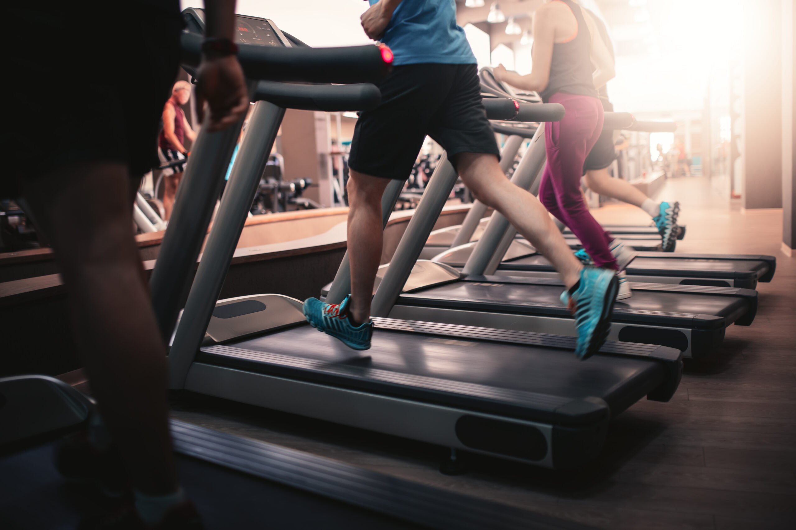 People running on treadmills in a gym.