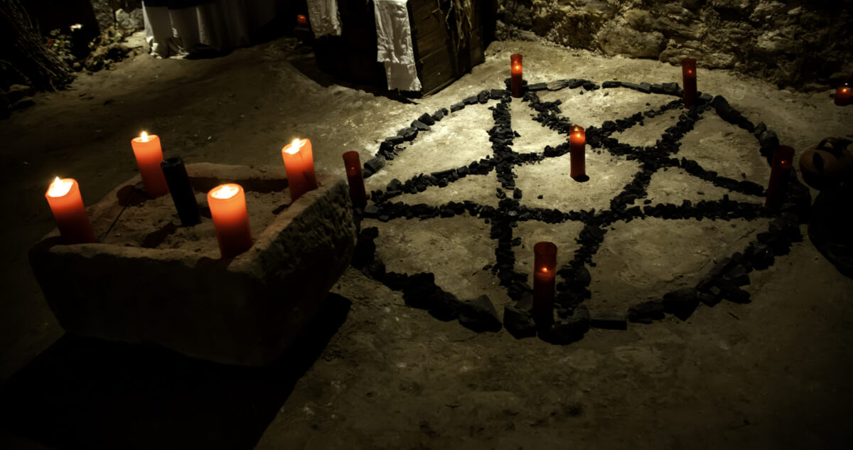 satanic ritual altar, pentagram with candles beside it.